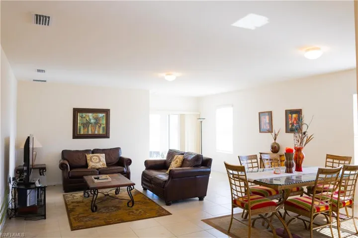 Living room featuring light tile patterned flooring and visible vents