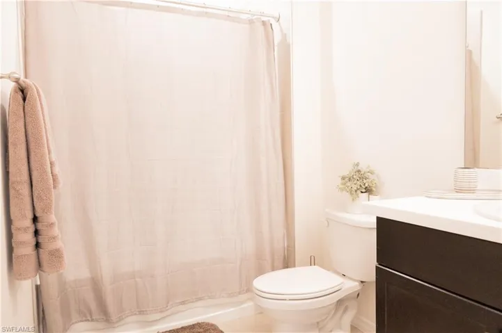 Full bath with a shower with curtain, toilet, and vanity