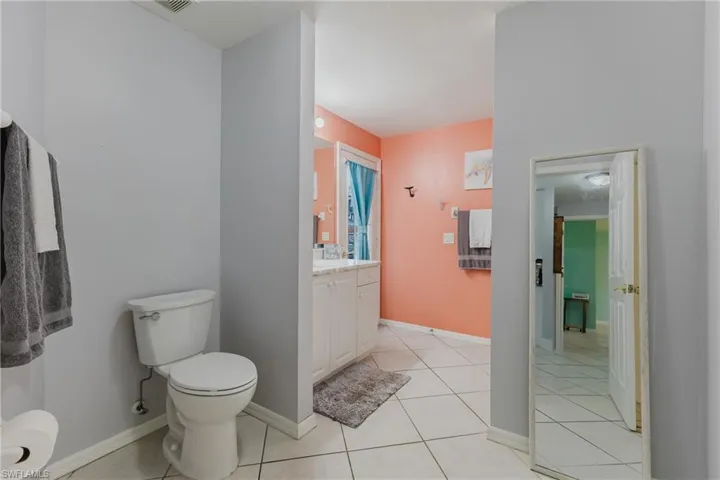 Pool Bathroom with toilet, vanity, tile patterned flooring, and baseboards