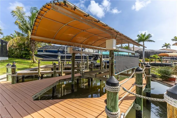 Dock area featuring boat lift and a water view