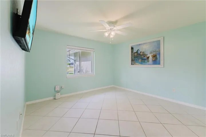 Spare room featuring ceiling fan, tile patterned floors, and baseboards