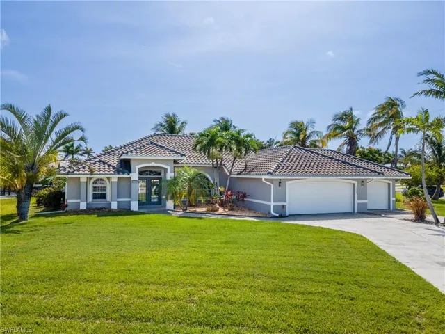 Mediterranean / spanish-style home with an attached garage, stucco siding, a front lawn, driveway, and a tile roof