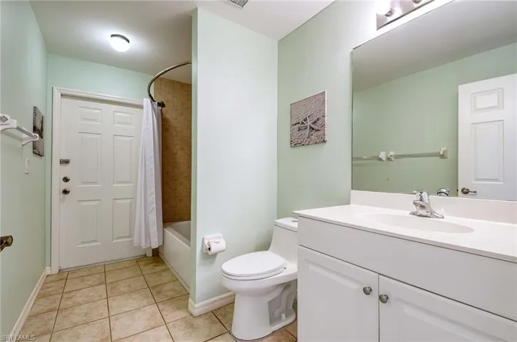 Full bathroom featuring tile patterned floors, vanity, shower / bath combination with curtain, and toilet