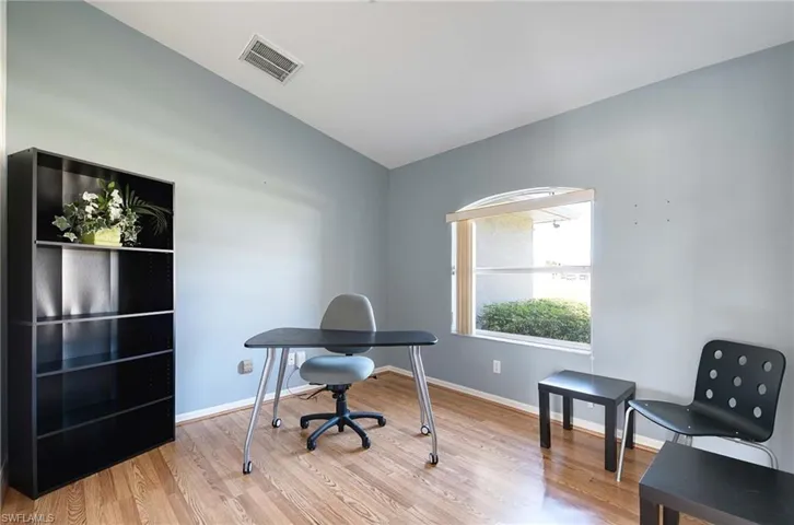 Office space featuring hardwood / wood-style floors and lofted ceiling