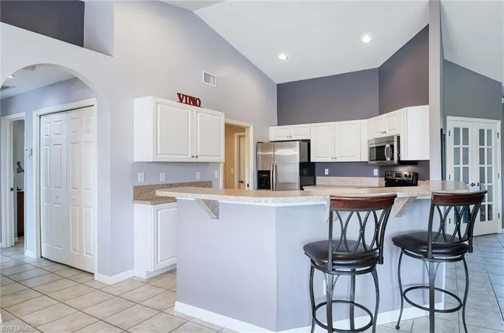 Kitchen featuring white cabinetry, a breakfast bar, a kitchen island, and stainless steel appliances
