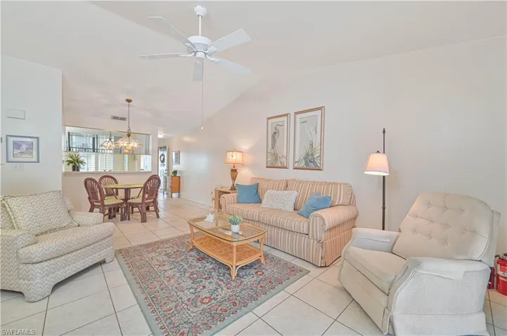Living area featuring vaulted ceilings, tile flooring, and a ceiling fan