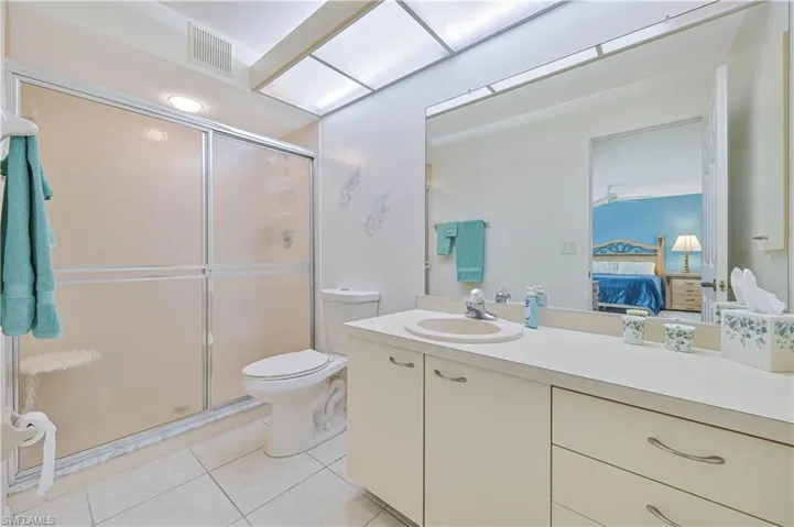 Bathroom featuring a large vanity with an integrated sink, white cabinetry, and a full-width mirror