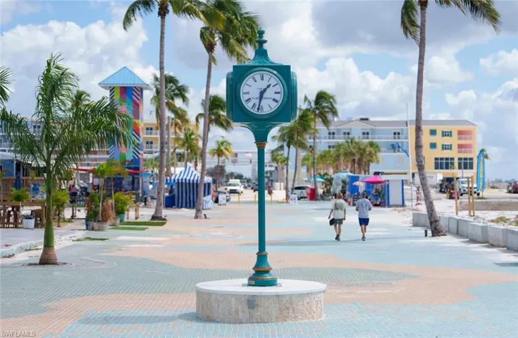 Clock tower with a teal finish, set on a circular stone base