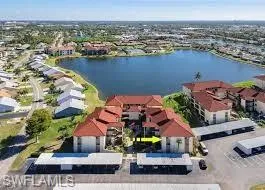 Condominium complex with terracotta tile roofing and white stucco exteriors