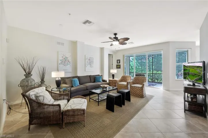 Living area with baseboards, visible vents, a ceiling fan, and light tile patterned floors