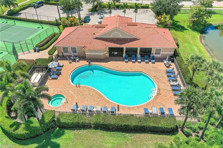 Community pool featuring a hot tub, fence, and a patio area