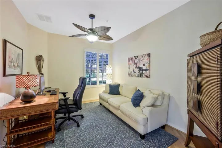 Office featuring wood finished floors, baseboards, ceiling fan, and visible vents