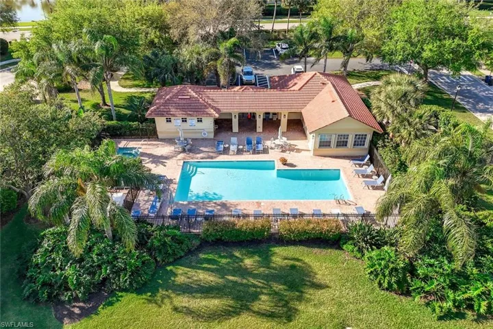 Community pool with a fenced backyard, a patio, and a yard