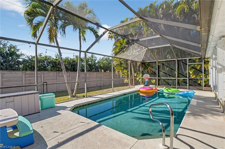 View of swimming pool featuring a sunroom, a lanai, a fenced backyard, and patio surround