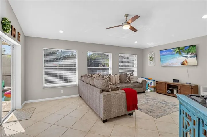 Living area featuring a ceiling fan, light tile patterned flooring, and recessed lighting