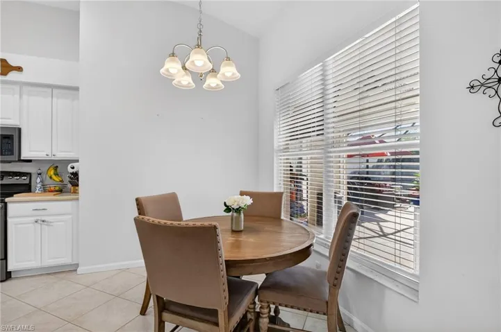 Dining area with suspended lighting, lofted ceiling, and light tile patterned floors