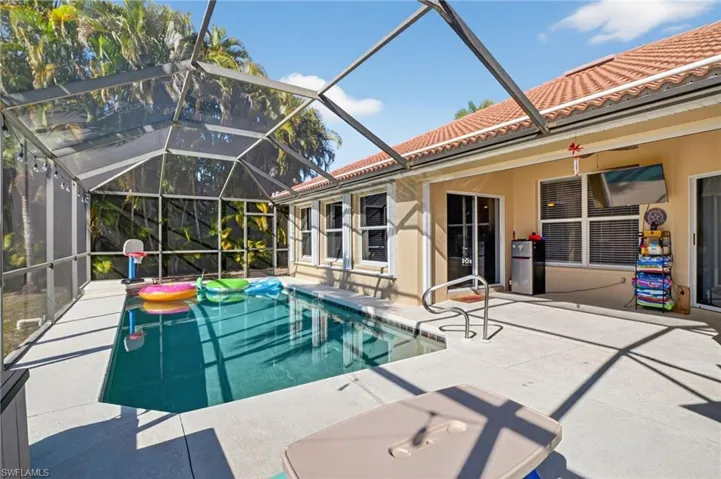 Swimming pool with a lanai, a patio, and a sunroom