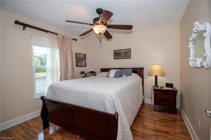 Bedroom with wood finished floors, baseboards, and ceiling fan
