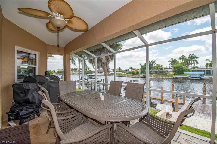 Sunroom featuring a water view, outdoor dining space, and ceiling fan