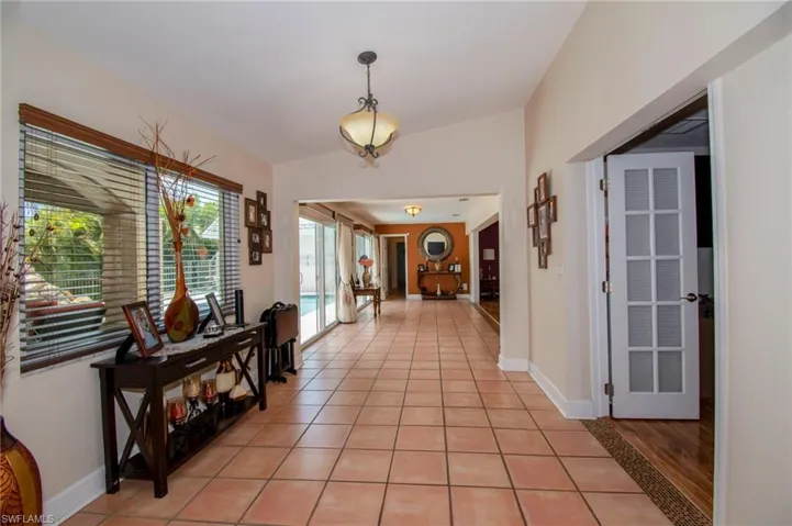 Hall with baseboards and light tile patterned floors