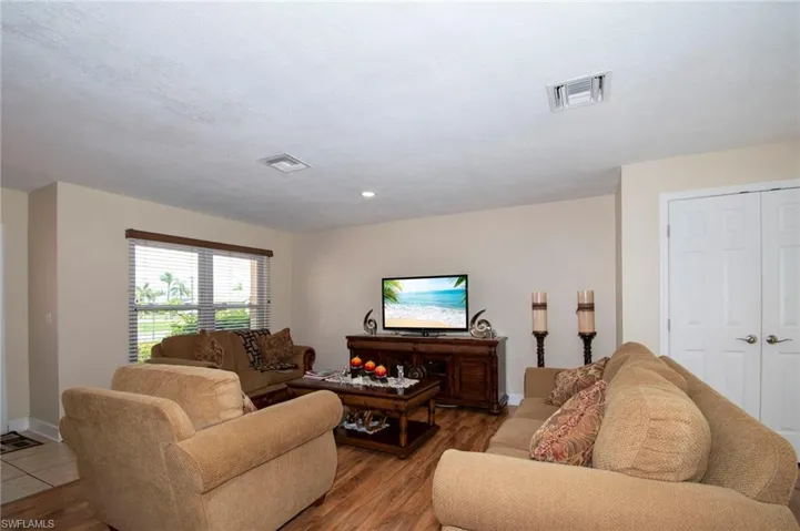 Living room with baseboards, wood finished floors, and visible vents