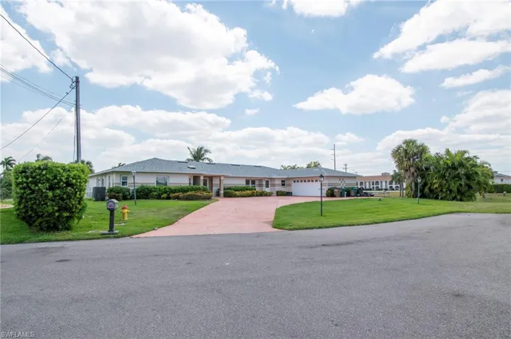 Ranch-style home with concrete driveway, a front lawn, and a garage
