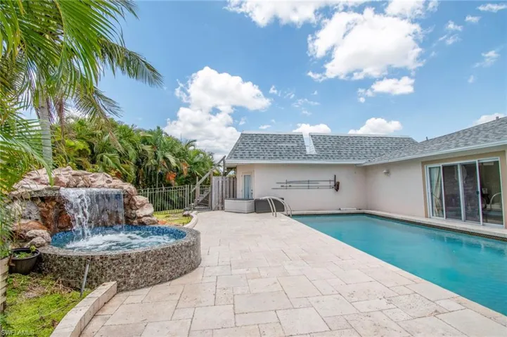 View of swimming pool featuring a patio area, a fenced in pool, a hot tub, and fence