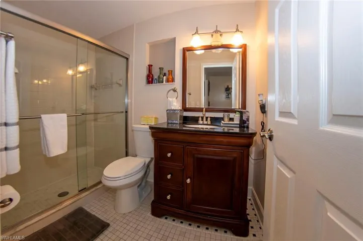 Bathroom featuring vanity, tile patterned flooring, a shower stall, and toilet