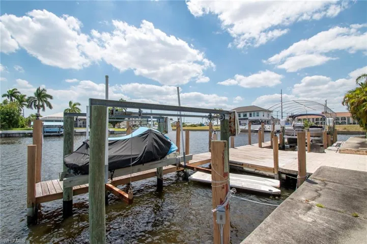 Dock area featuring boat lift and a water view