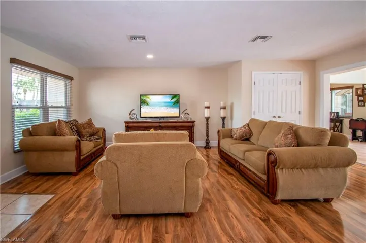 Living area with baseboards, wood finished floors, visible vents, and recessed lighting