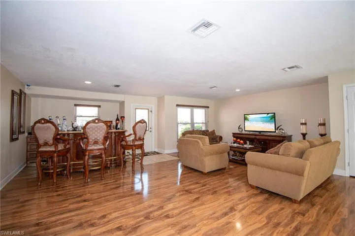 Living room featuring wood finished floors, visible vents, and baseboards