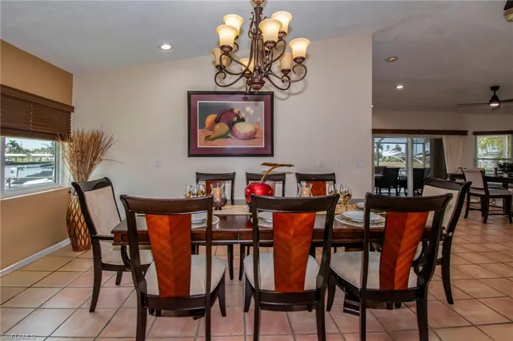 Dining room featuring recessed lighting, an inviting chandelier, a healthy amount of sunlight, and light tile patterned floors