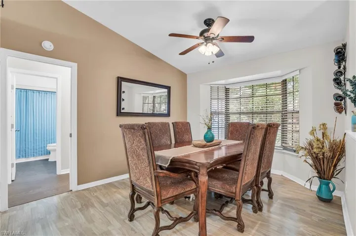 Dining area featuring light wood-type flooring, Bay window, and vaulted ceiling