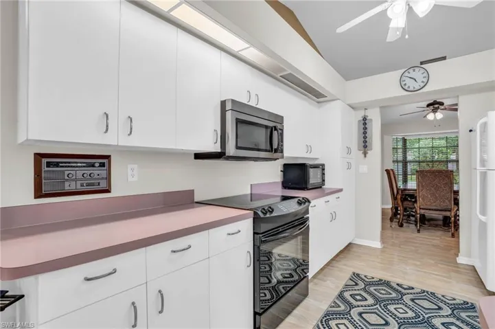 Kitchen featuring plenty of storage in white cabinets and reach-in pantry