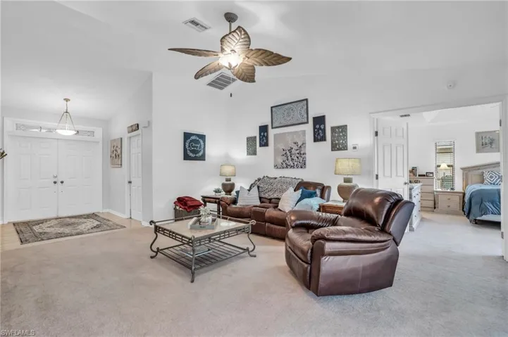 living room with ceiling fan and vaulted ceiling