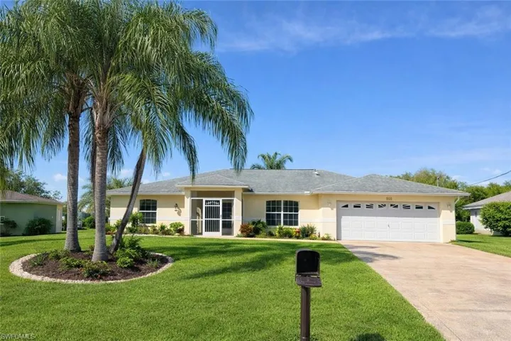 Ranch-style house with a front lawn, stucco siding, and driveway