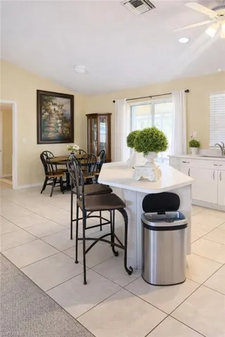 Dining space featuring lofted ceiling, light tile patterned floors, ceiling fan, and recessed lighting