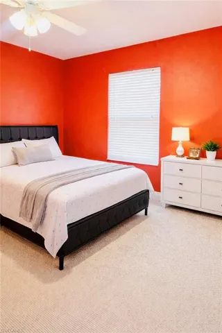 Bedroom with a ceiling fan and light carpet
