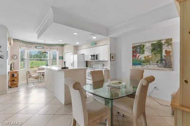 Dining room with light tile patterned floors and recessed lighting