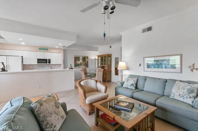 Living area with light tile patterned flooring, crown molding, ceiling fan, and recessed lighting