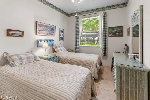 Bedroom with light tile patterned floors and ceiling fan