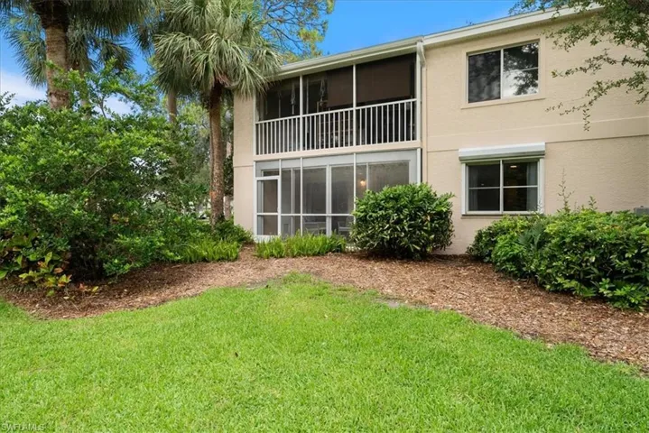 yard view features electric shutters on back window and screened lanai