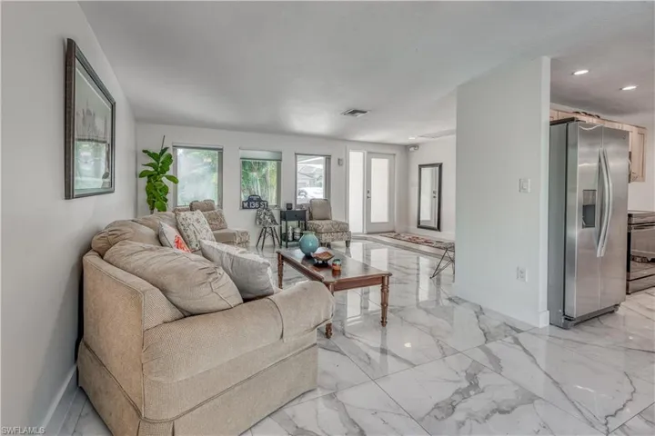 Living room with visible vents, baseboards, marble finish floor, and recessed lighting