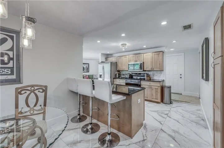 Kitchen featuring a breakfast bar, visible vents, recessed lighting, and appliances with stainless steel finishes
