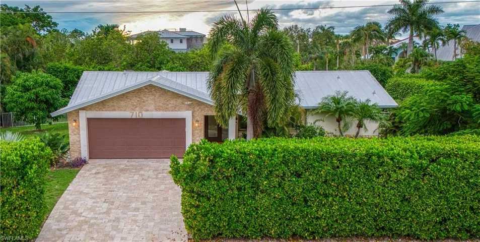View of front of house featuring metal roof, an attached garage, and decorative driveway