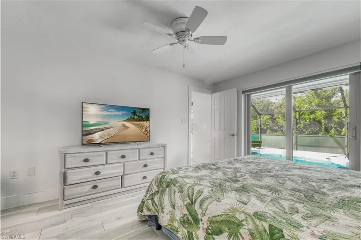 Bedroom with ceiling fan, baseboards, access to exterior, and light wood-style flooring