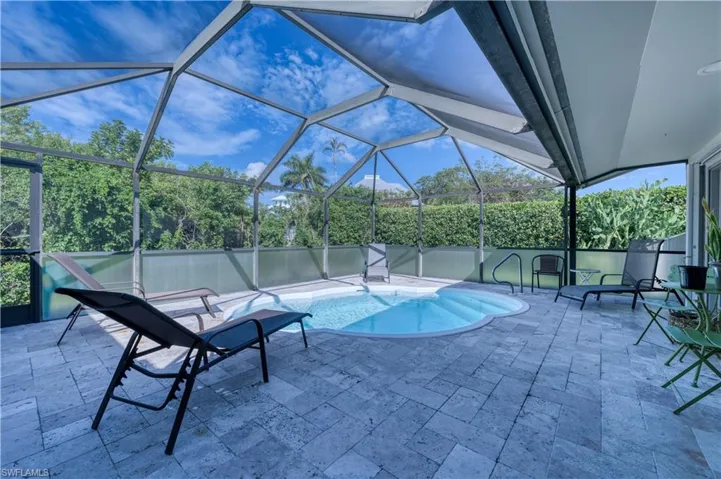 Outdoor pool featuring glass enclosure and a patio area