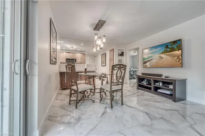Dining room with baseboards, marble finish floor, recessed lighting, and an inviting chandelier