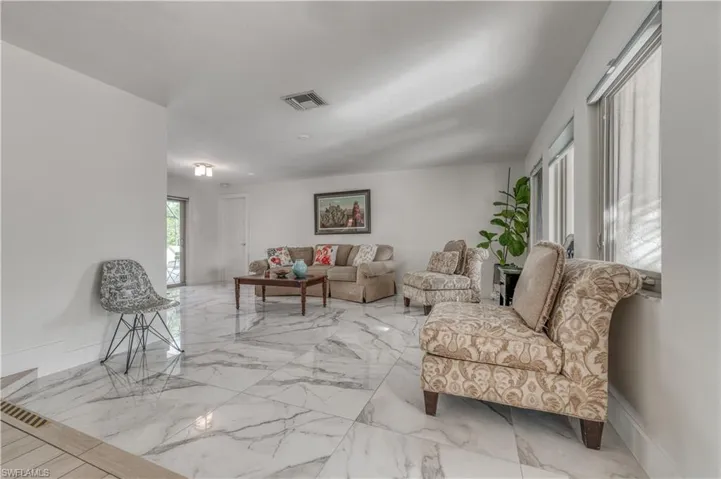 Living area with visible vents and marble finish floor
