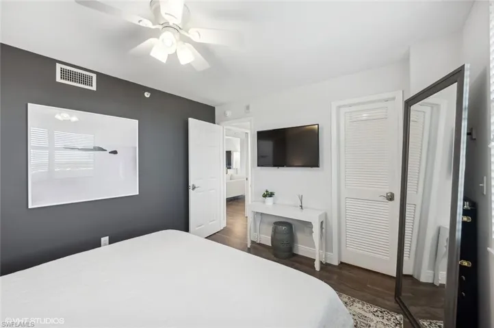 Bedroom featuring ceiling fan, dark wood-type flooring, and a closet